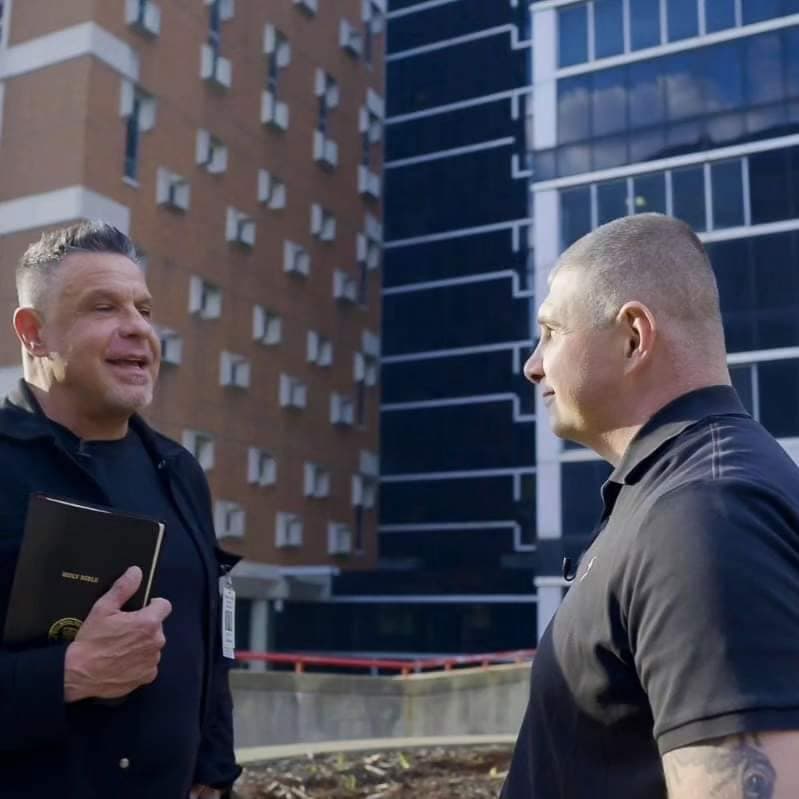A Semper Fi Mission Prison Ministry volunteer holding a Bible while talking with another man outside